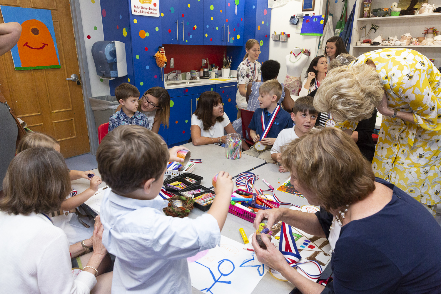 Terapeuta wskazuje na rysunek dziecka z burzliwymi chmurami i przebijającymi promieniami