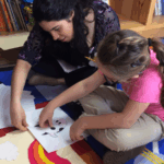 Grupa nauczycieli i głuchych uczniów na szkoleniu z migowego w sali wykładowej