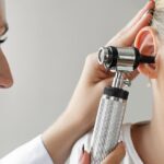 Kiedy zabrać dziecko do audiologa? Niepokojące sygnały, które rodzice zbyt często bagatelizują mama z małym dzieckiem siedzi naprzeciw audiologa w jasnym gabinecie